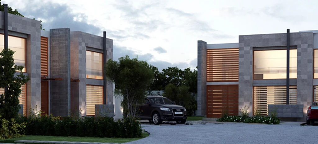 Render de Domaine III al atardecer: casas de piedra gris con ventanas iluminadas y un vehículo oscuro en el acceso.